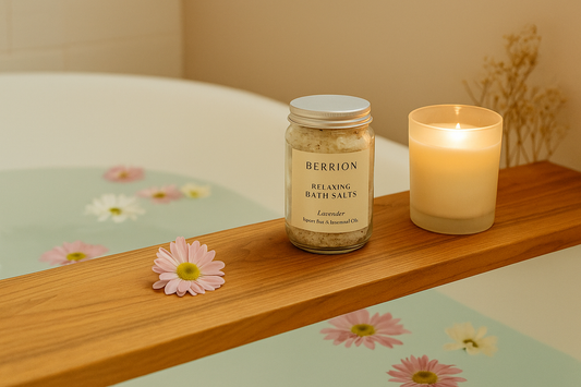Berrion relaxing bath salts and candle on a wooden bath tray with floating flowers in a warm spa-like bath scene.